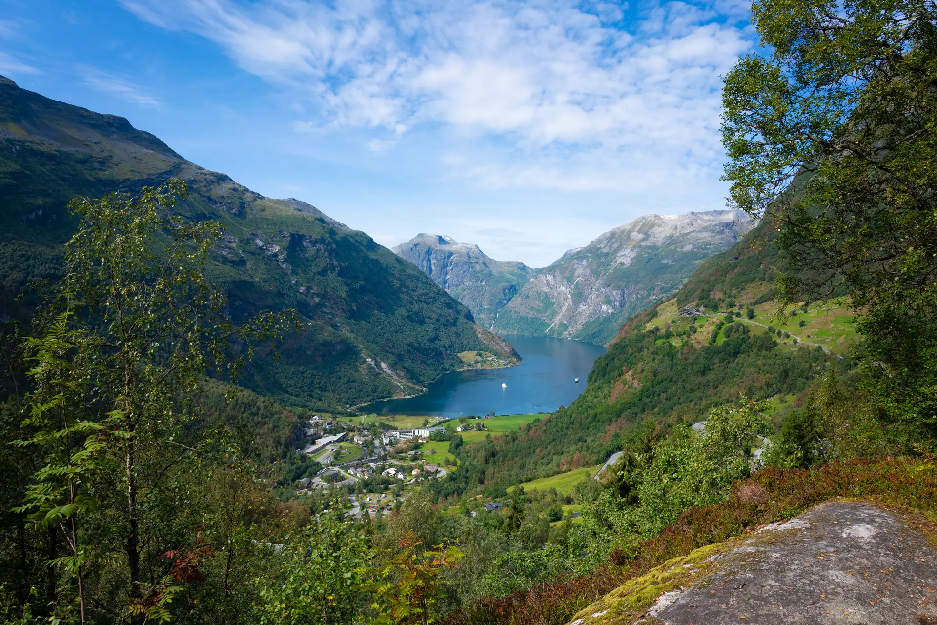 Speilblank fjord med frodige åser