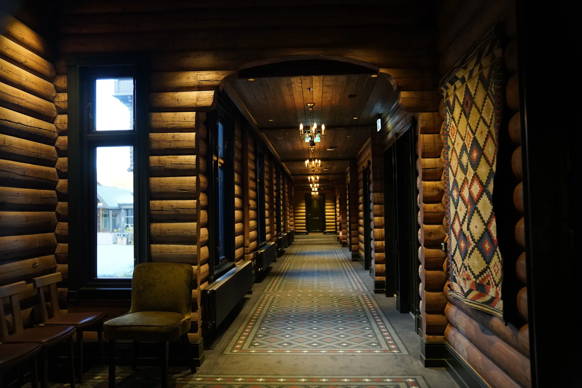 Varm og innbydende lodgekorridor i lunt tømmer med levende lys