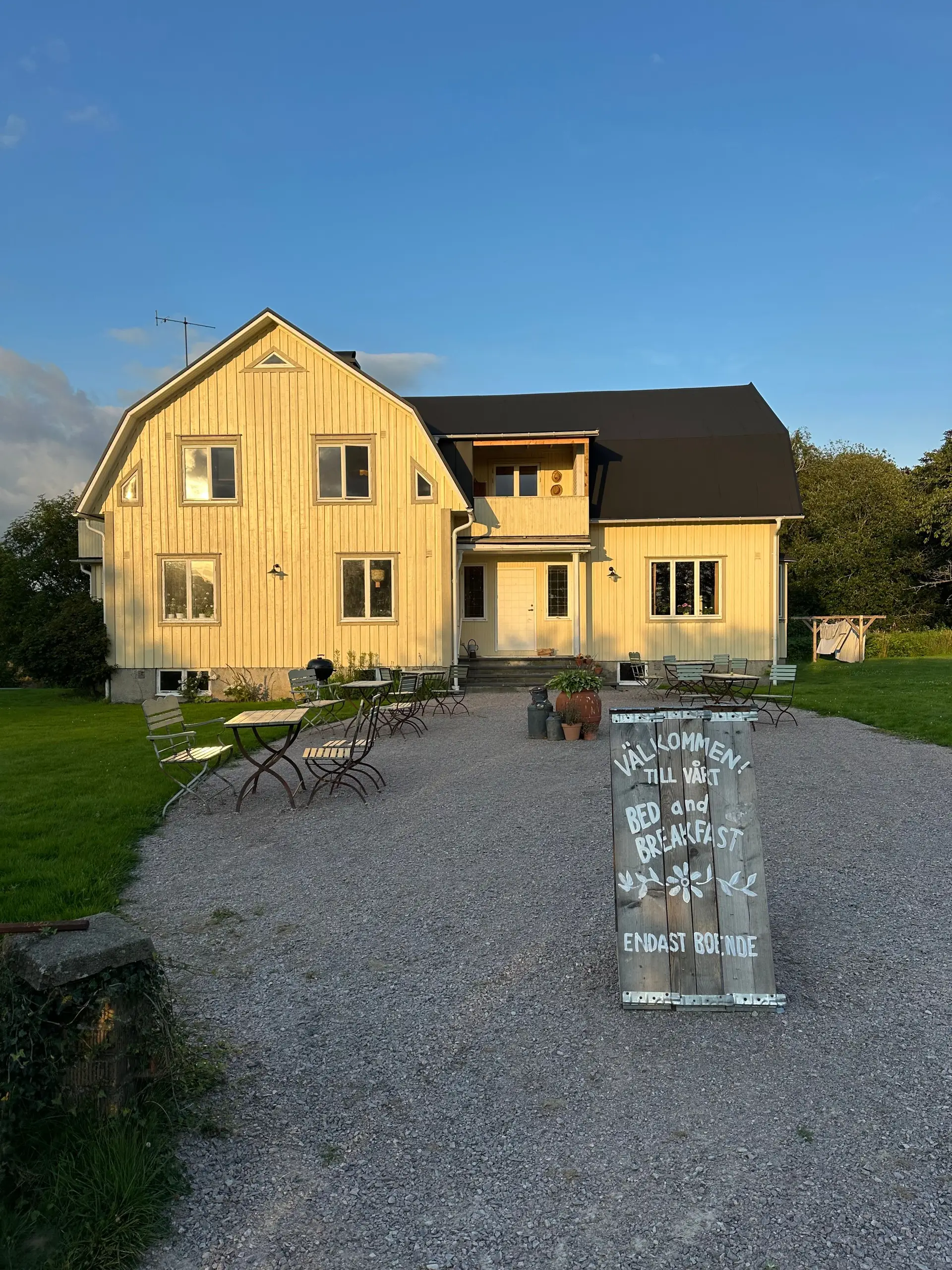 Utsikt mot lodge ved solnedgang med romslig og opplyst adkomst